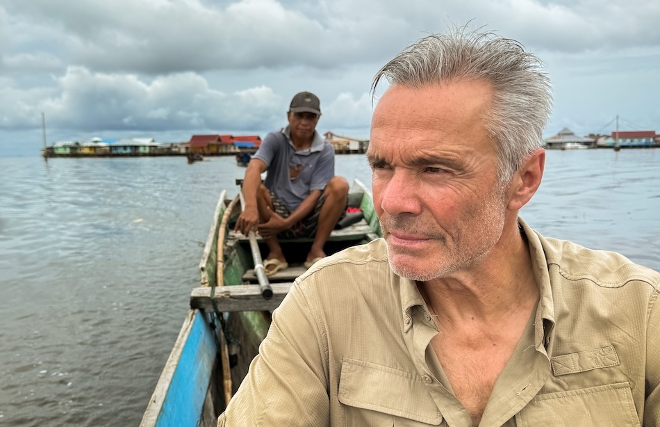 Captivating underwater exploration with a diver heading towards floating villages.