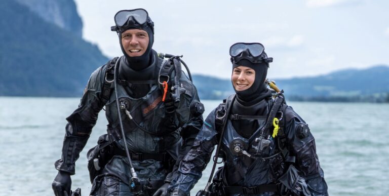 Des plongeurs souriants émergent de l'eau, prêts à explorer les merveilles sous-marines.