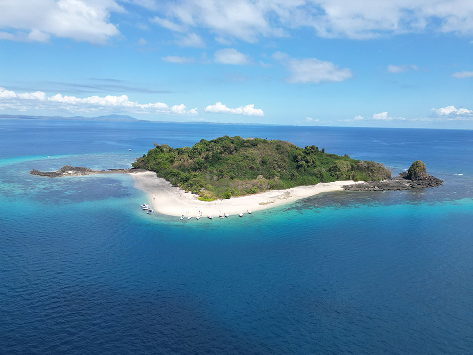 Tropical island surrounded by crystal-clear waters, ideal for scuba diving and marine exploration.