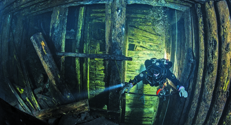 Un plongeur explore une épave sous-marine, révélant la beauté du monde aquatique.