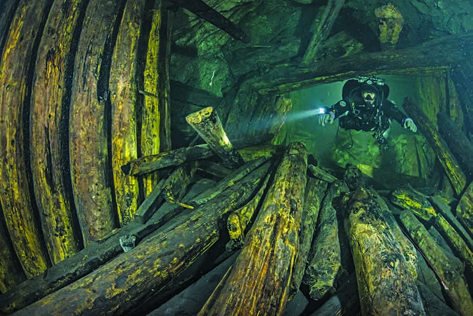Scuba diving in a wreck, revealing fascinating and mysterious wooden structures.