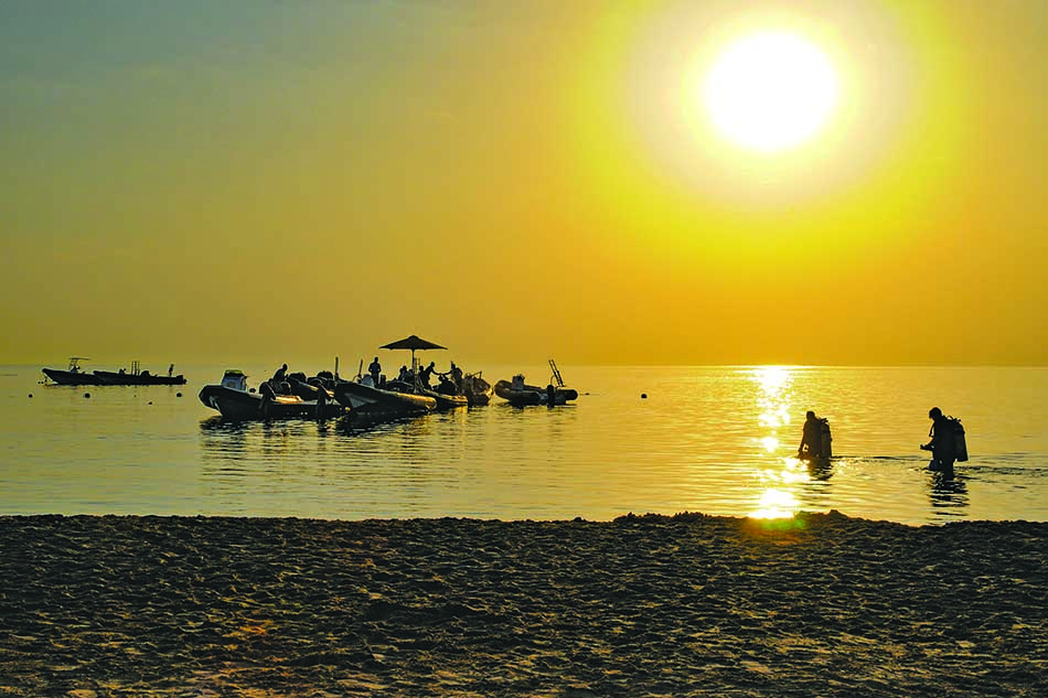 Diving at sunset with divers preparing to explore the underwater world.