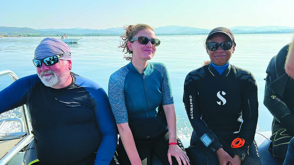 Smiling divers prepare to explore the underwater wonders on a sunny day.