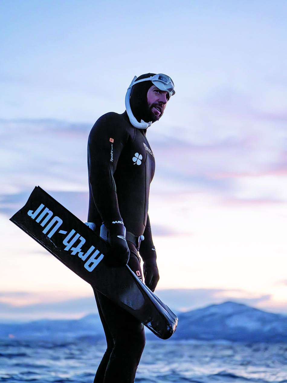 Freediver at sunset, ready to explore underwater wonders.