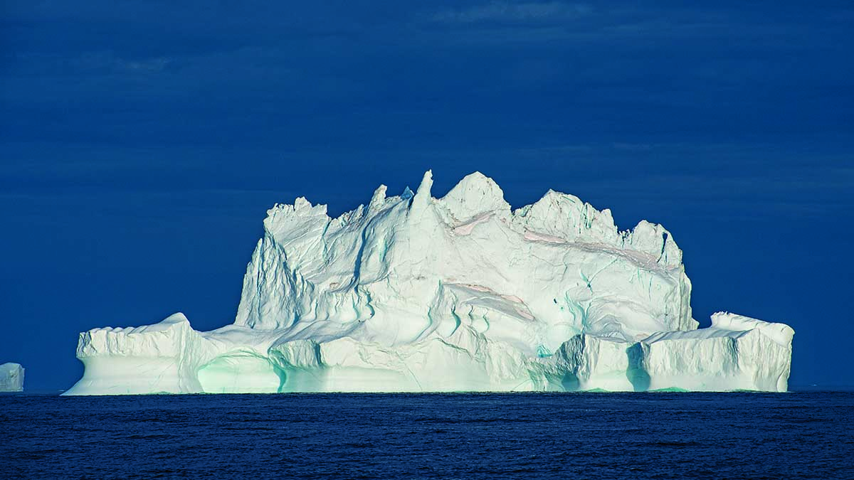 Iceberg majestueux flottant dans des eaux profondes, symbole de la beauté sous-marine.
